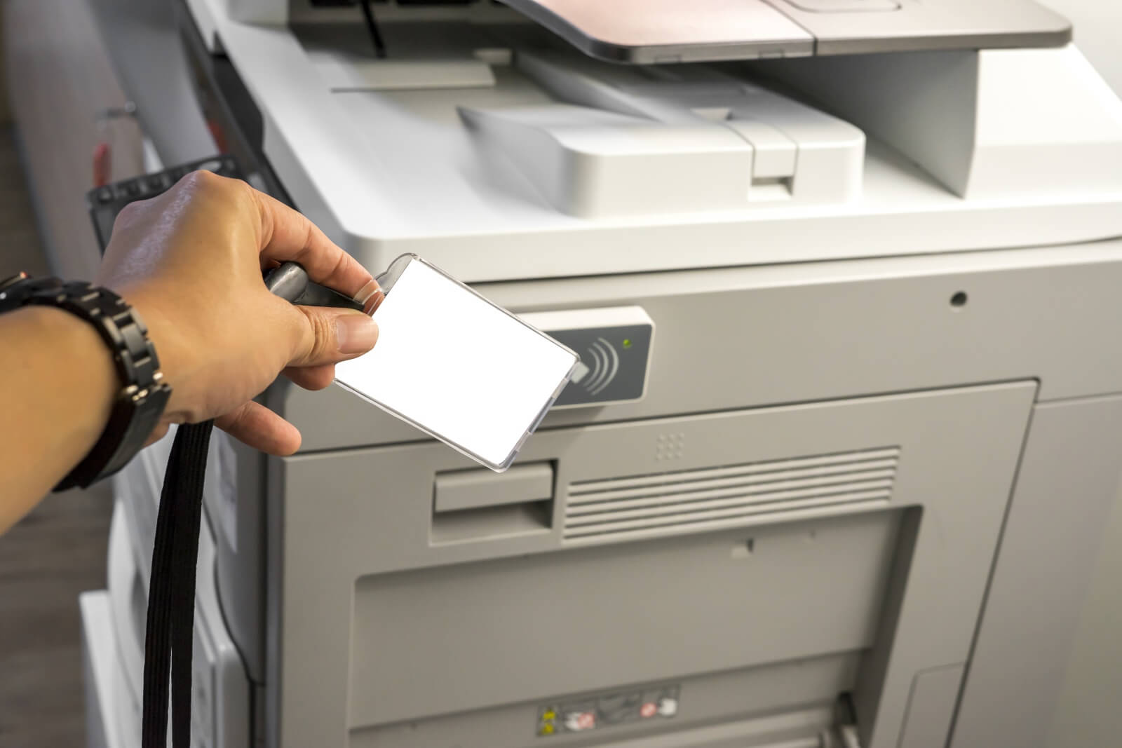 Office worker scans ID for secure printing